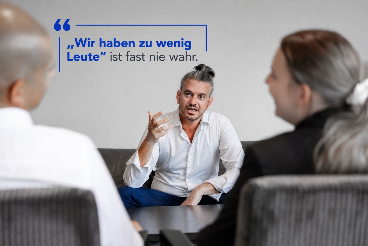 Donato Blandolino talking to two people at a meeting table, accompanied by the quote: We don’t have enough people is almost never true.